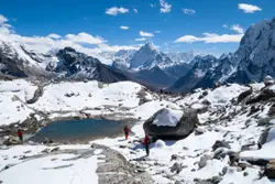 Person Standing On Top Of A Snowy Mountain