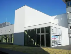 Building With A Large White Building Behind It