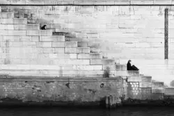 Person Sitting On A Ledge Near A Wall