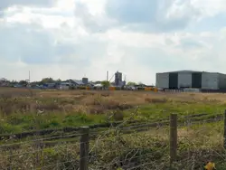 Large Building With A Fence And A Train On The Tracks