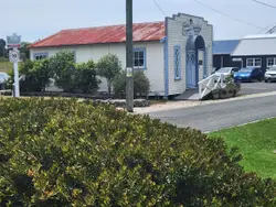 House With A Large White Fence And A Small White Building