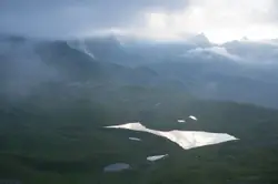 White Plane Flying Over A Mountain