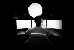 Person Sitting On A Chair In A Dark Room