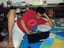 Man Laying On A Bed With A Laptop