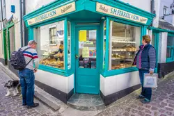 Man Standing Next To A Food Stand