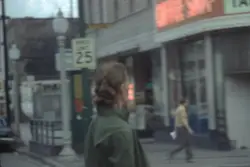 Man Walking Down A Street With A Skateboard