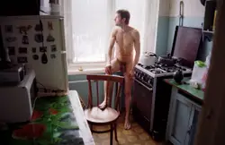 Woman Sitting On A Chair In A Kitchen