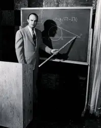 Man In A Suit And Tie Holding A Black And White Photo