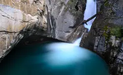 River With A Waterfall And A Rock Wall
