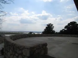Large Stone Wall With A Bench And A Group Of People