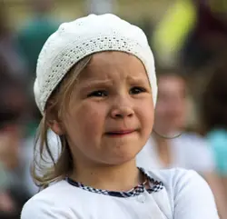Young Girl Wearing A White Hat And Holding A White And Pink Flower