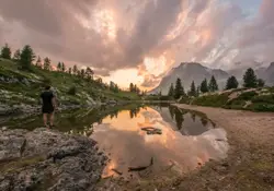 Man Standing On A Hill With A Lake