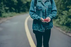 Woman Walking Down A Street With A Skateboard