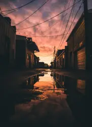Row Of Wooden Benches Sitting On A Wet Street