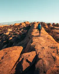 Person Walking On A Dirt Path With A Mountain