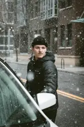 Man Is Standing In The Snow With A Snowboard