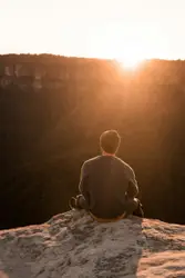 Man Sitting On A Rock On A Sunny Day