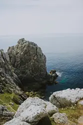 Rocky Outcrop With A Lighthouse And A Mountain