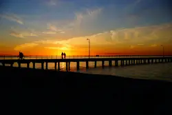 Lone Person Is Standing On A Bench Overlooking The Water