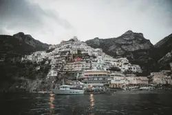 Boat Is Docked In The Water Near A Mountain