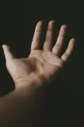 Person Holding A White Object In Their Hand