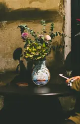 Vase With A Flower On It Sitting On A Table