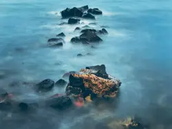 Rocky Beach With A Bunch Of Rocks And A Lighthouse