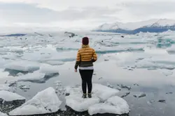 Person Standing On A Snowy Hill With A Mountain
