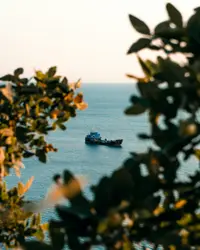 Boat Is In The Water Near A Small Island