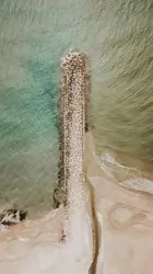 Wooden Pole On The Beach Near The Water