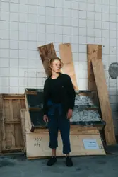 Man Standing In Front Of A Wooden Box