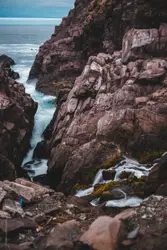Ocean wave hitting on rock cliff