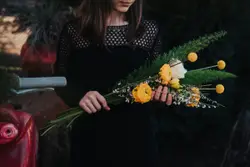 Woman holding bouquet of white and yellow flowers