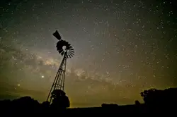 Silhouette of windmill under starry sky