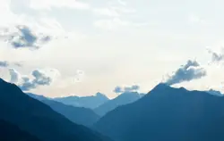 View of mountains under white skies