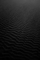 A black and white photo of a sand dune