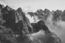 Grayscale photography of mountain with smoke