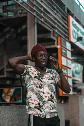 Man in red cap and white red and blue floral button up 