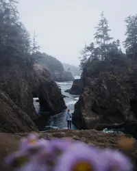 Person in blue shirt standing on brown rock formation n