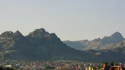 Brown mountain with houses during daytime