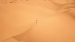 A lone person walking through the sand dunes