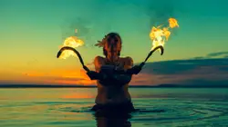 Woman holding sickles with fire