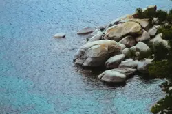 Rocky Outcrop With A Lake And A Mountain