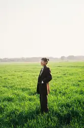 Woman in black long sleeve shirt standing on green gras