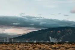 White wooden fence on brown field under gray cloudy sky