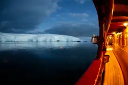 Ship floating on ocean heading to ice burg