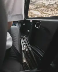 Person sitting inside car beside door\