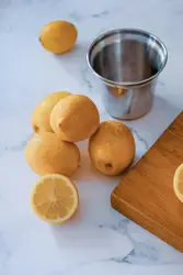 Lemon fruits and gray stainless steel cup