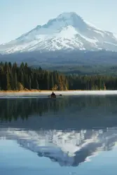 Reflection of mountain alps on body of water during day