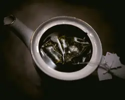 Macro photography of tea bag in white ceramic teapot
